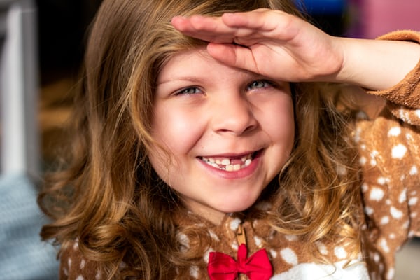 young girl smiling with missing front teeth