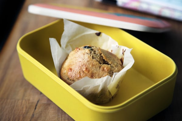 yellow lunch box with a single muffin inside