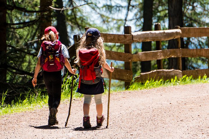 two children hiking with backpacks