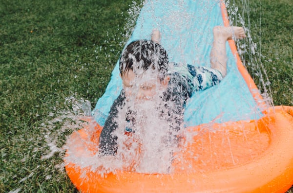 kid going down slip and slide